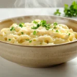 A bowl of pasta with creamy cheese powder sauce, garnished with herbs