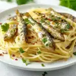 How do Italians eat canned sardines? A mouthwatering display of Italian dishes featuring sardines, including pasta, salads, and bruschetta