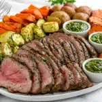 Juicy and tender tri tip platter with vibrant sides on a marble table