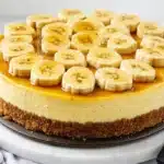 A banana foster cheesecake with caramelized banana topping on a modern platter