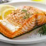 Perfectly cooked king salmon recipe with crispy skin, garnished with dill and lemon
